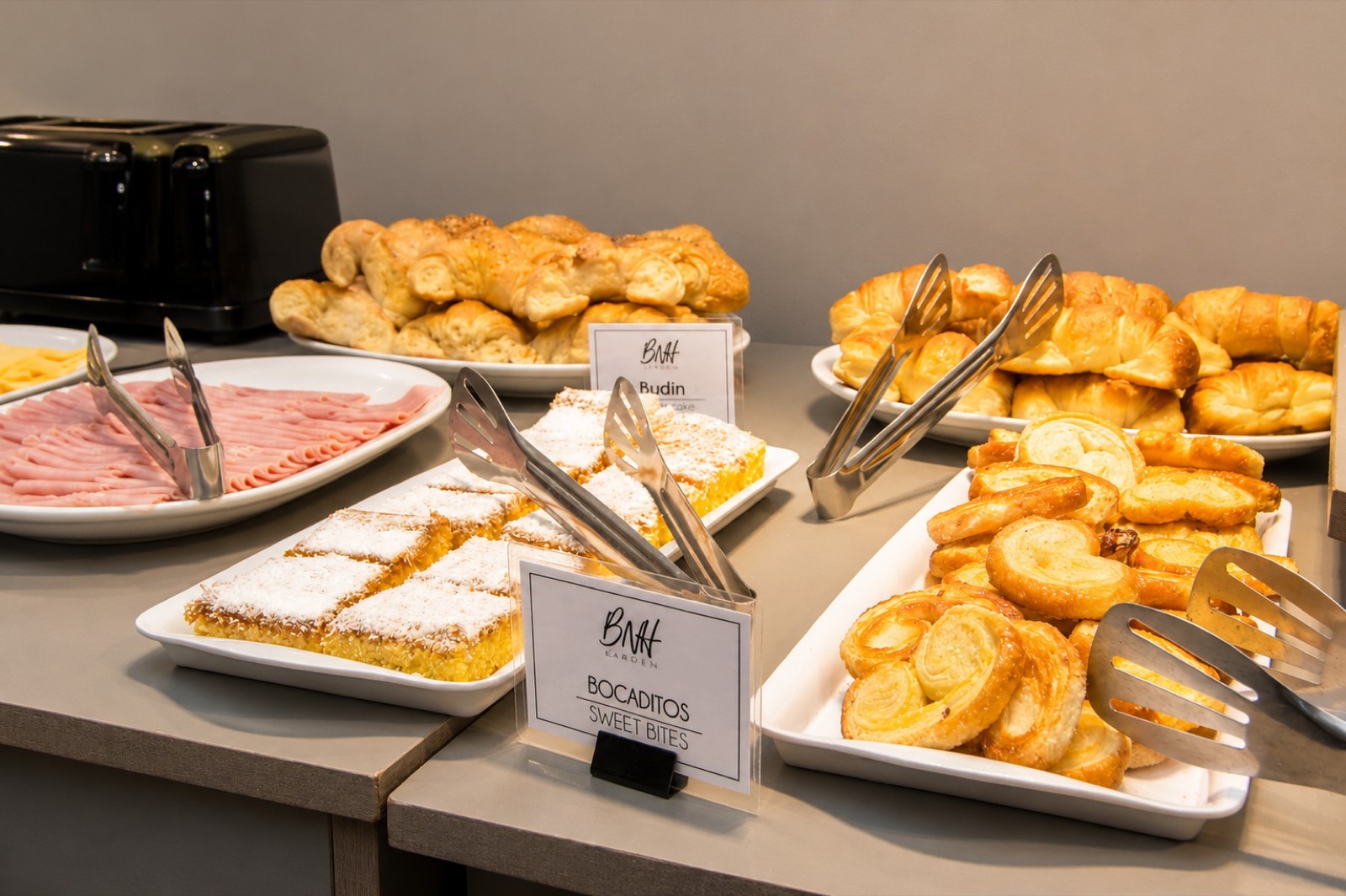Mesa de desayuno buffet con facturas, medialunas y fiambres